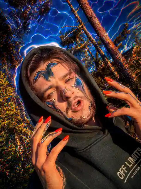 Surreal hooded forest portrait with chrome face fragments.